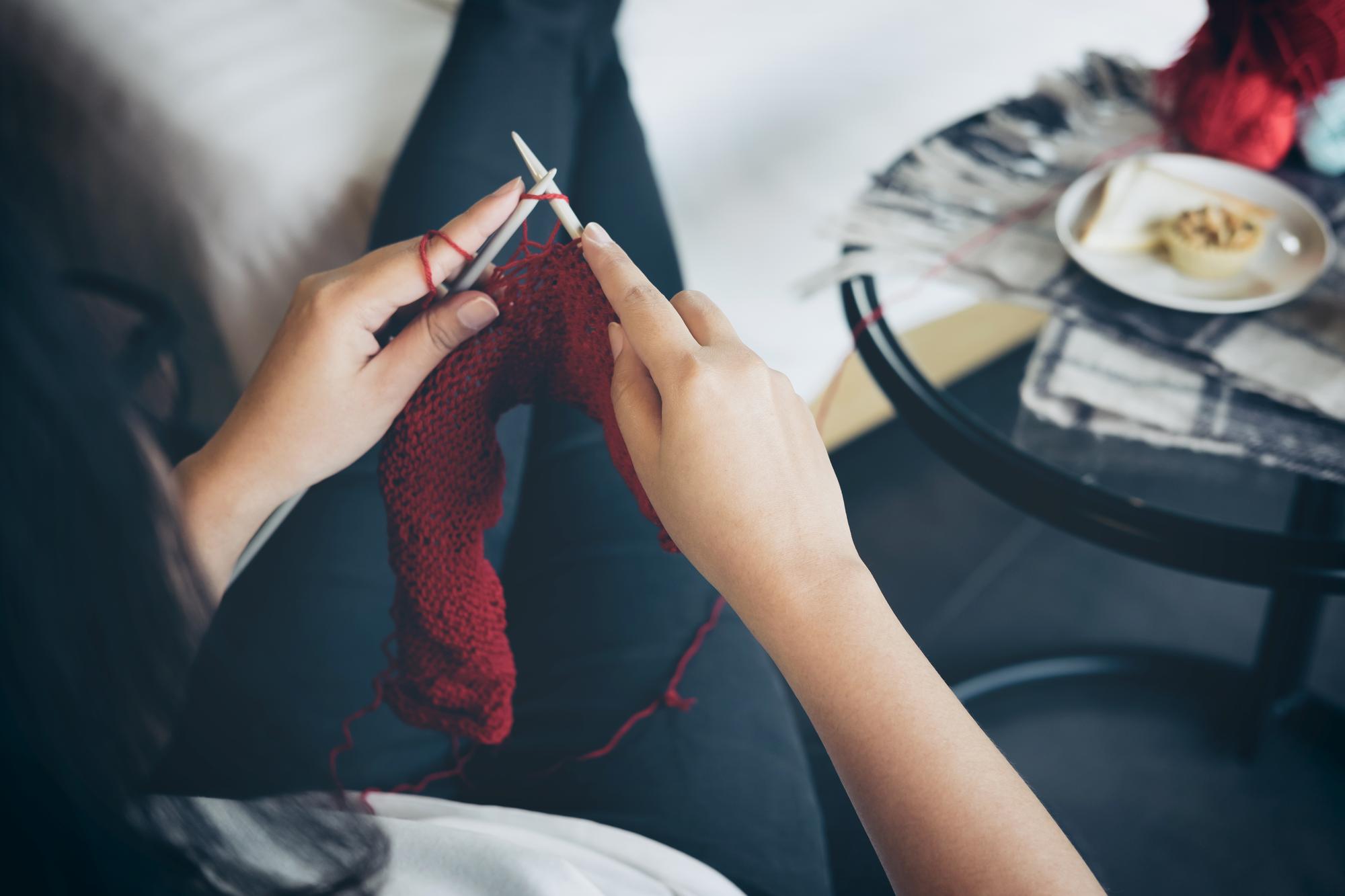 artist sewing embroidery in studio